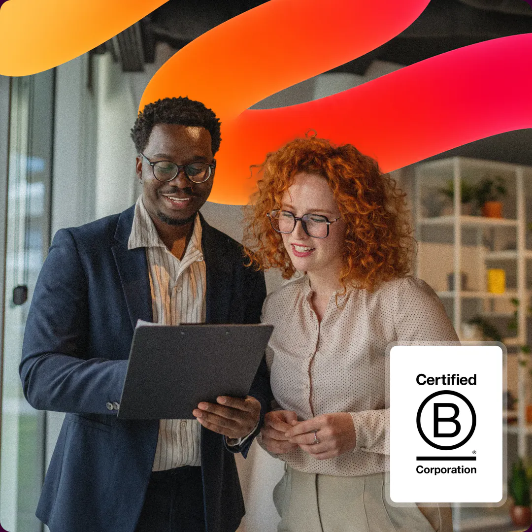 Deux collaborateurs Map & Match échangeant devant un ordinateur, à côté du label B Corp