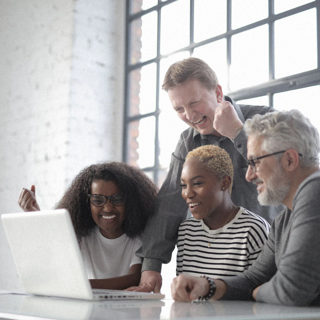 A manager and their team around a laptop