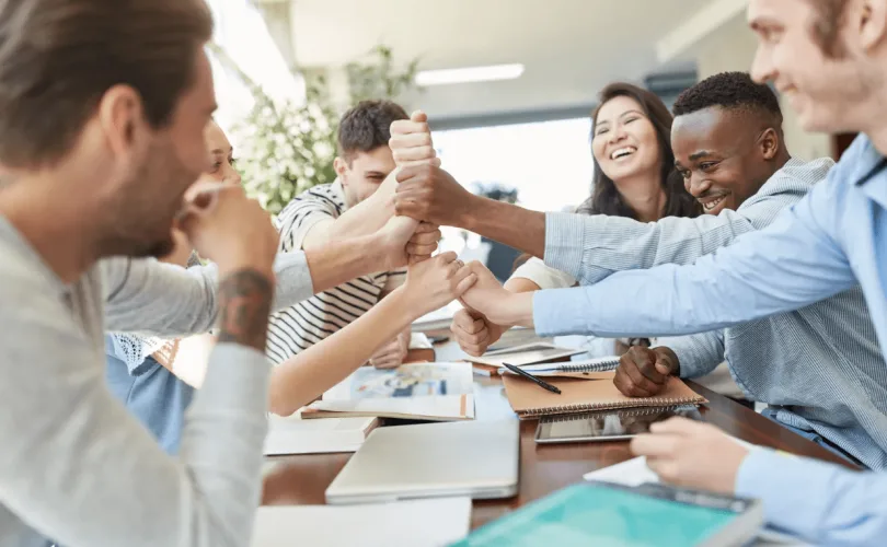 un groupe de collaborateur se serrant la main lors d'une réunion professionnelle